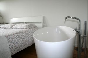 außergewöhnliches Schlafzimmer mit großer Badewanne