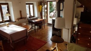 Von Küche aus gesehen. Rechts: Schlafsofa, Kommode mit Fernseher. Links: Esstisch, Antik-Schreibtisch