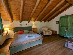 Schlafzimmer mit Doppelbett, TV, Ausgang auf den Balkon im OG